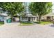Charming single-story home with covered parking and a gravel driveway lined with timber at 110 Highland Ave, Franklin, IN 46131