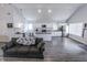 Modern open-plan living area with a sleek kitchen, comfortable seating, and grey wood floors at 110 Highland Ave, Franklin, IN 46131