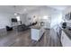 Open concept living space features modern kitchen with island, white cabinets, and wood-look flooring at 110 Highland Ave, Franklin, IN 46131