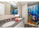 This bathroom boasts a double sink vanity with gray countertops and a shower with nautical themed curtain at 1114 E 234Th St, Sheridan, IN 46069