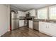 Modern kitchen with stainless steel appliances, white cabinets, and dark countertops at 1114 E 234Th St, Sheridan, IN 46069