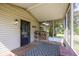 Cozy screened-in porch with outdoor rug, door, and stack of firewood for cool nights at 1114 E 234Th St, Sheridan, IN 46069
