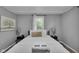 Cozy bedroom with comfortable bedding, decorative lamps, and natural light at 1141 N Shadeland Ave, Indianapolis, IN 46219