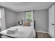 Neutral bedroom with fresh linens, and a window offering a view of the outdoors at 1141 N Shadeland Ave, Indianapolis, IN 46219
