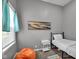 Cozy bedroom featuring an orange beanbag chair, art and a comfortable bed at 1141 N Shadeland Ave, Indianapolis, IN 46219