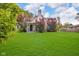 Charming home with a manicured lawn and mature trees under a blue, partly cloudy sky at 1141 N Shadeland Ave, Indianapolis, IN 46219
