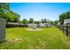 Wide angle of a large, green backyard featuring a fire pit and perimeter fencing for privacy at 120 Hoss Rd, Indianapolis, IN 46217