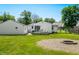Expansive backyard with lush lawn, mature trees, a wooden deck, and a cozy fire pit area at 120 Hoss Rd, Indianapolis, IN 46217