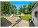 Wide backyard showcases a wooden deck, mature trees, seating and a fire pit, for outdoor enjoyment at 120 Hoss Rd, Indianapolis, IN 46217