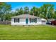 Inviting ranch home with a bright blue front door, surrounded by lush greenery and a well kept lawn at 120 Hoss Rd, Indianapolis, IN 46217