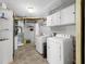 Well-lit laundry room with white washer, dryer, storage shelves and utility sink at 120 Hoss Rd, Indianapolis, IN 46217