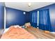 Bright blue bedroom with a window, wood floors, and room for personalization at 1217 Old Vines Trl, Greenwood, IN 46143