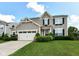 Charming two-story home featuring manicured lawn, flower boxes, attached two-car garage, and tasteful, neutral vinyl siding at 1217 Old Vines Trl, Greenwood, IN 46143
