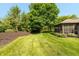 Large, verdant backyard featuring mature trees, lush lawn and manicured beds at 1220 Pintail Ct, Columbus, IN 47201