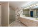 Bathroom featuring double vanity, large mirror, and a tiled glass door shower at 1220 Pintail Ct, Columbus, IN 47201