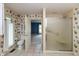 Bright bathroom with floral wallpaper, toilet, and glass door shower at 1220 Pintail Ct, Columbus, IN 47201
