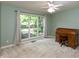 A well-lit bedroom with a ceiling fan, large window, and classic wooden roll top desk at 1220 Pintail Ct, Columbus, IN 47201