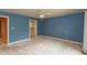 A bedroom with blue walls, carpet floors, and a view into the en-suite bath at 1220 Pintail Ct, Columbus, IN 47201