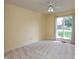 Bright bedroom with neutral carpet, a ceiling fan, and a large window providing ample natural light at 1220 Pintail Ct, Columbus, IN 47201