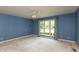Spacious bedroom with blue walls, neutral carpet, and a large window offering plenty of natural light at 1220 Pintail Ct, Columbus, IN 47201
