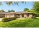 Well-maintained brick ranch with green lawn, mature trees, and an attached two-car garage at 1220 Pintail Ct, Columbus, IN 47201