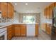 Bright kitchen featuring oak cabinets, tile floors, white appliances, and an eat-in nook at 1220 Pintail Ct, Columbus, IN 47201