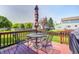 Red backyard deck with table, four chairs, and umbrella at 13068 Lamarque Pl, Fishers, IN 46038