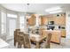 Bright dining area with wood table and chairs, a stylish light fixture, and view to the kitchen at 13068 Lamarque Pl, Fishers, IN 46038