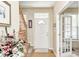 Inviting foyer features hardwood floors, a staircase, and a view into an adjacent room with a glass door at 13068 Lamarque Pl, Fishers, IN 46038