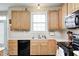 Traditional kitchen featuring wooden cabinets, a window over the sink, and black appliances at 13068 Lamarque Pl, Fishers, IN 46038