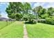 The spacious backyard has grass and lots of mature trees in the space at 1346 W 27Th St, Indianapolis, IN 46208