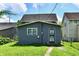 Backyard view of this home featuring a gray exterior, well-maintained lawn, and a patterned screen door at 1346 W 27Th St, Indianapolis, IN 46208