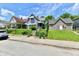 View from the street shows a home with a gray exterior, landscaping, and black wrought iron fencing at 1346 W 27Th St, Indianapolis, IN 46208