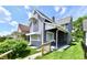 The gray exterior is contrasted by the mature landscaping, awnings, and front porch with dark metal railings at 1346 W 27Th St, Indianapolis, IN 46208