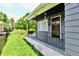 View of the front porch with metal railings, gray siding, and a concrete path leading to the front door at 1346 W 27Th St, Indianapolis, IN 46208