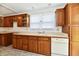 Functional kitchen featuring wood cabinets, neutral countertops, and natural light at 1346 W 27Th St, Indianapolis, IN 46208
