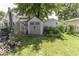 Backyard with greenhouse, shed, greenery, and grass at 1393 Wayne St, Noblesville, IN 46060