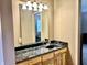Bathroom with granite countertop vanity, mirror, and wooden drawers with knobs at 1437 E Pleasant Run Pkwy S Dr, Indianapolis, IN 46203