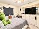 A cozy bedroom features a large bed, flat-screen TV, ample storage, and a bright window at 1437 E Pleasant Run Pkwy S Dr, Indianapolis, IN 46203