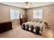 A cozy bedroom with carpet, a queen bed, windows, and furniture at 1437 E Pleasant Run Pkwy S Dr, Indianapolis, IN 46203