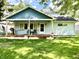Charming home featuring a welcoming covered porch, blue siding, and well-manicured front lawn at 1437 E Pleasant Run Pkwy S Dr, Indianapolis, IN 46203