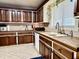 Well-lit kitchen featuring wood cabinets, ample counter space, and tile flooring at 1437 E Pleasant Run Pkwy S Dr, Indianapolis, IN 46203