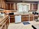 Charming kitchen featuring wooden cabinetry, tile countertops, and stainless steel faucet at 1437 E Pleasant Run Pkwy S Dr, Indianapolis, IN 46203
