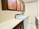 Functional laundry room with wooden cabinets, lots of countertop space, washer, and dryer at 1437 E Pleasant Run Pkwy S Dr, Indianapolis, IN 46203