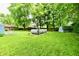 Spacious backyard featuring an above ground pool, large trees, a shed, and a well-manicured lawn at 1445 Biloxi Ln, Beech Grove, IN 46107