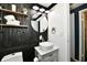 Modern bathroom with a unique round mirror, ship-lap style black wall, and stylish fixtures at 1445 Biloxi Ln, Beech Grove, IN 46107