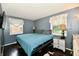 Cozy bedroom with hardwood floors and comfortable bedding. Two windows with white curtains provide natural light at 1445 Biloxi Ln, Beech Grove, IN 46107
