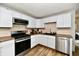 Modern kitchen features stainless steel appliances, wood backsplash, light countertops, and wood-look flooring at 1445 Biloxi Ln, Beech Grove, IN 46107