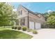 A view of the home's exterior featuring a two-car garage, manicured lawn, and lush landscaping at 15201 Slateford Rd, Noblesville, IN 46062