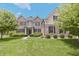 Charming two-story brick home featuring lush landscaping, a manicured lawn, and a welcoming front facade at 15201 Slateford Rd, Noblesville, IN 46062